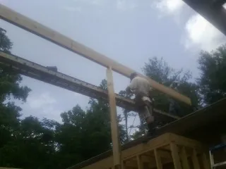 Carpenter setting a ridge beam over a new addition frame — Ice Dam Removal by Roofing Brothers in Mission
